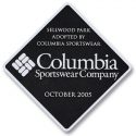 Custom metal black diamond-shaped plaque with a white engraved logo and engraving text indicating 'Sellwood Park adopted by Columbia Sportswear Company, October 2005'.