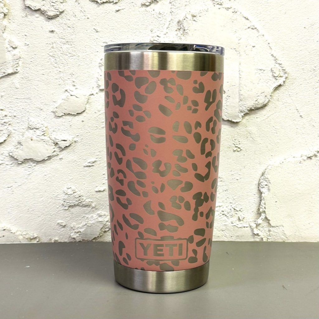 Custom engraved YETI tumbler with leopard print pattern on a pink cup, exposing the silver metal underneath.