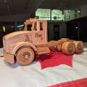 Handmade wooden truck model with laser engraved company logo on the cab door.